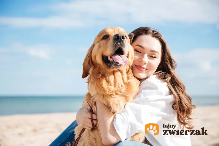 Dziewczyna przytulająca psa z miłością na plaży, jak się bawić z psem i ile czasu dziennie poświęcać na zabawę z psem