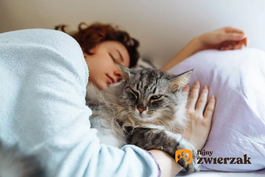 Kot śpi z kobietą w łóżku