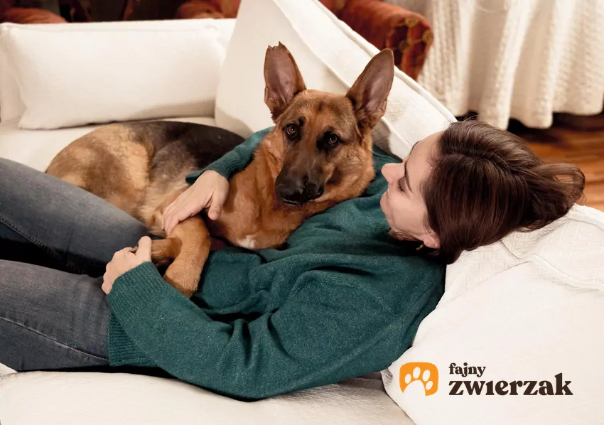 Kobieta leży z psem na kanapie